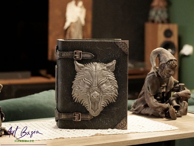 Ręcznie wykonana Wilcza Księga – drewniana szkatułka w formie księgi z wilczą głową na okładce, technika mix media i efekt postarzonej skóry