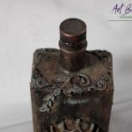 Detal artystycznej karafki fantasy – relief z gliny czaszka w koronie, efekt rdzy i patyny ArtBasia