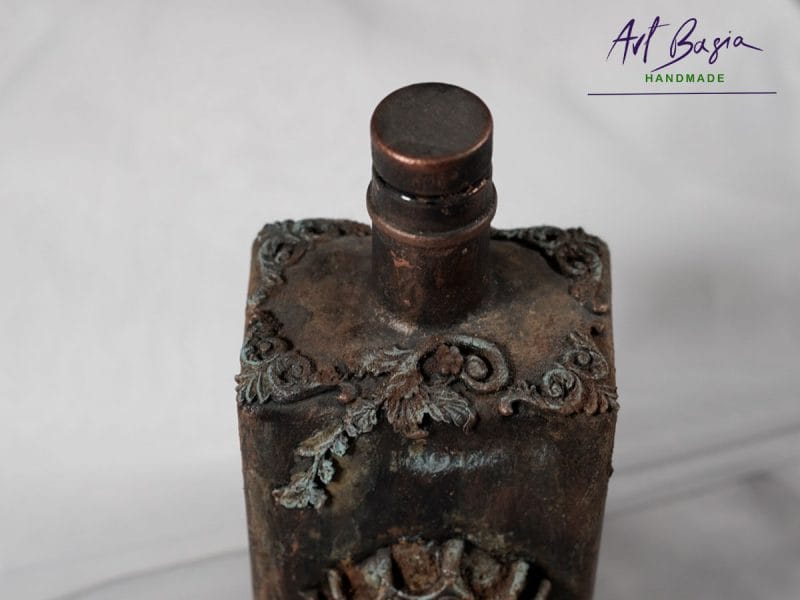 Detal artystycznej karafki fantasy – relief z gliny czaszka w koronie, efekt rdzy i patyny ArtBasia