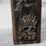 Detal artystycznej karafki fantasy – relief z gliny czaszka w koronie, efekt rdzy i patyny ArtBasia